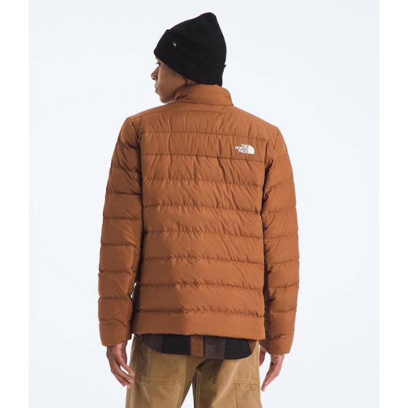 Load image into Gallery viewer, Person wearing a brown puffer jacket with a visible brand logo on a white background