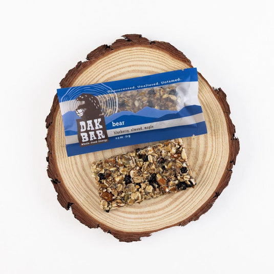 Dak Bar bear snack on a wooden log with a white background