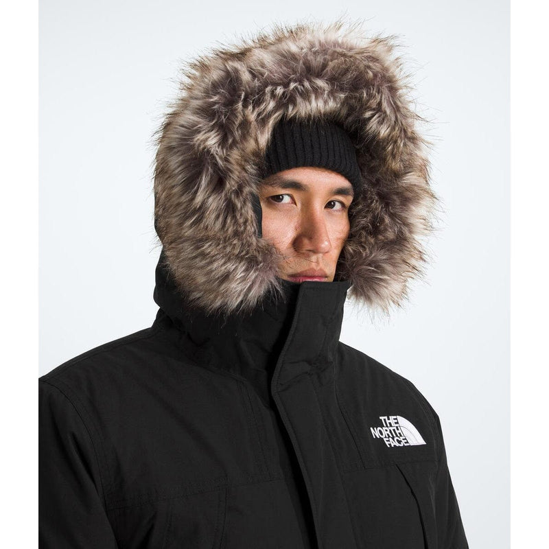 Load image into Gallery viewer, Person wearing a black winter coat with a fur-lined hood on a white background