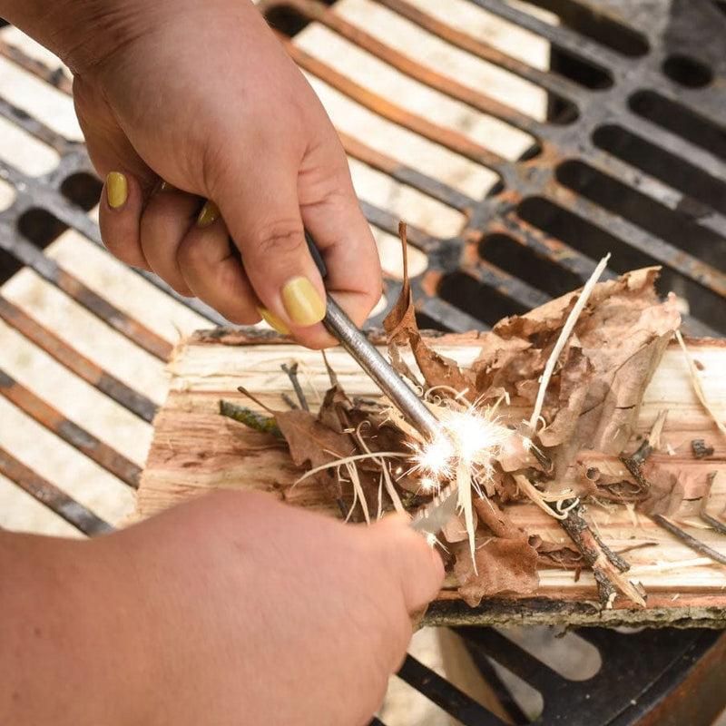 Load image into Gallery viewer, Person lighting dry leaves with a match on a grill
