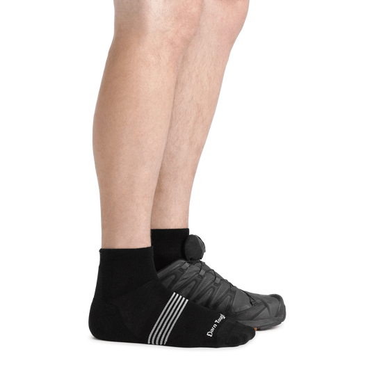 Black ankle socks worn with a black sneaker on a white background