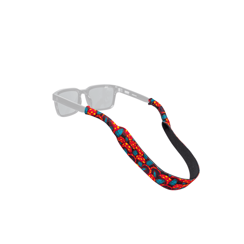 Load image into Gallery viewer, A pair of clear-lens sunglasses with a red, blue, and black patterned fabric strap, displayed on a solid white background.
