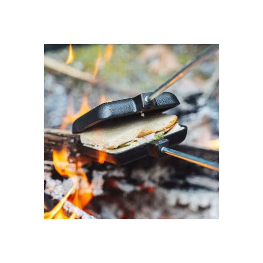 Campfire with a portable grill holding food over flames