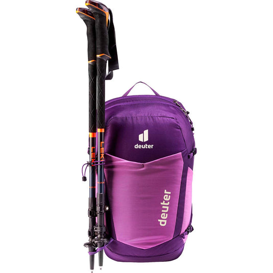 Purple backpack with ski poles attached on a white background