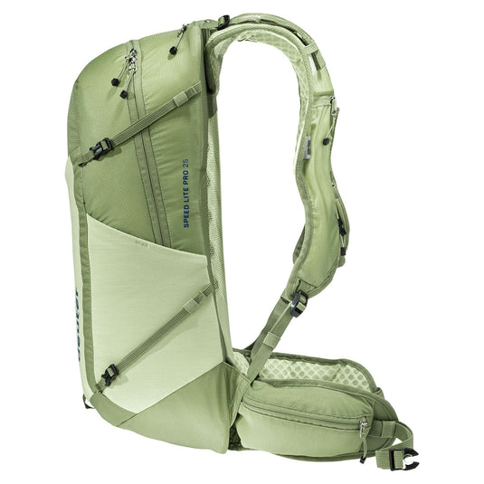 Green backpack with multiple compartments and straps on a white background