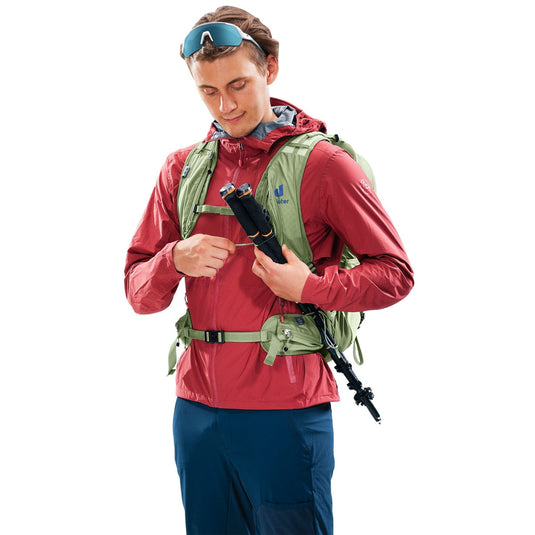 Man wearing a red jacket and green backpack holding a rifle on a white background