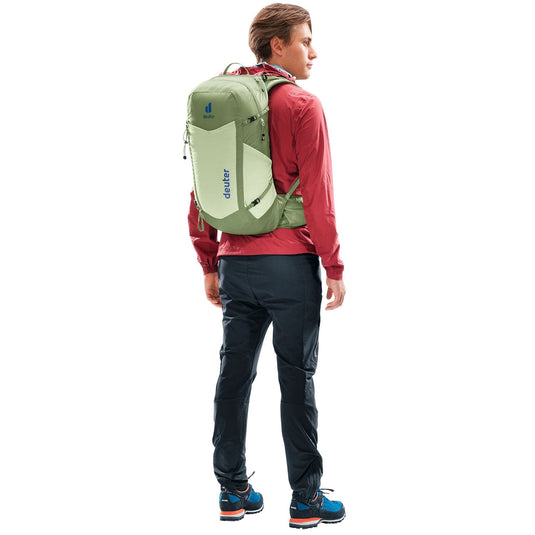 Person wearing a green backpack with a visible brand logo on a white background