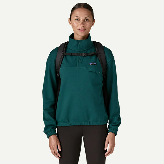 Person wearing black backpack straps and a buckle across the chest on a white background