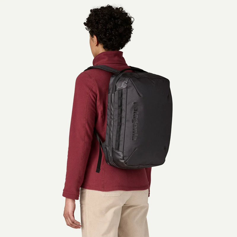 Load image into Gallery viewer, Person wearing a black Patagonia backpack on a white background
