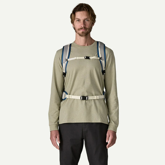 Man wearing a bag on his back with two shoulder straps, a strap across his chest and another across his wais