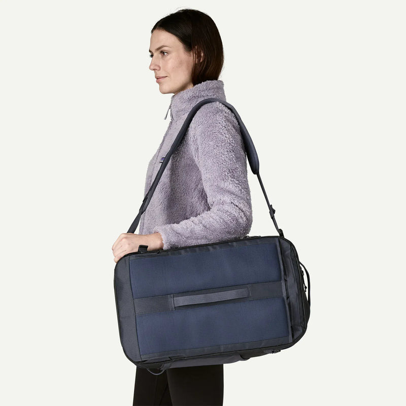 Load image into Gallery viewer, Woman carrying a navy blue duffel bag 
