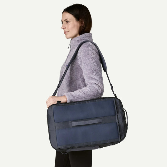 Woman carrying a navy blue duffel bag 
