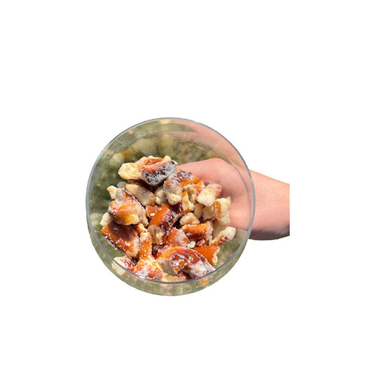 Hand holding a transparent container filled with pretzel bites on a white background