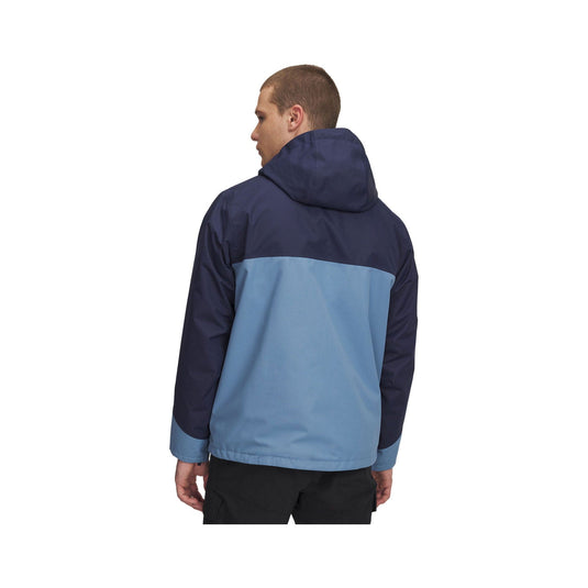 Person wearing a two-tone blue jacket on a white background