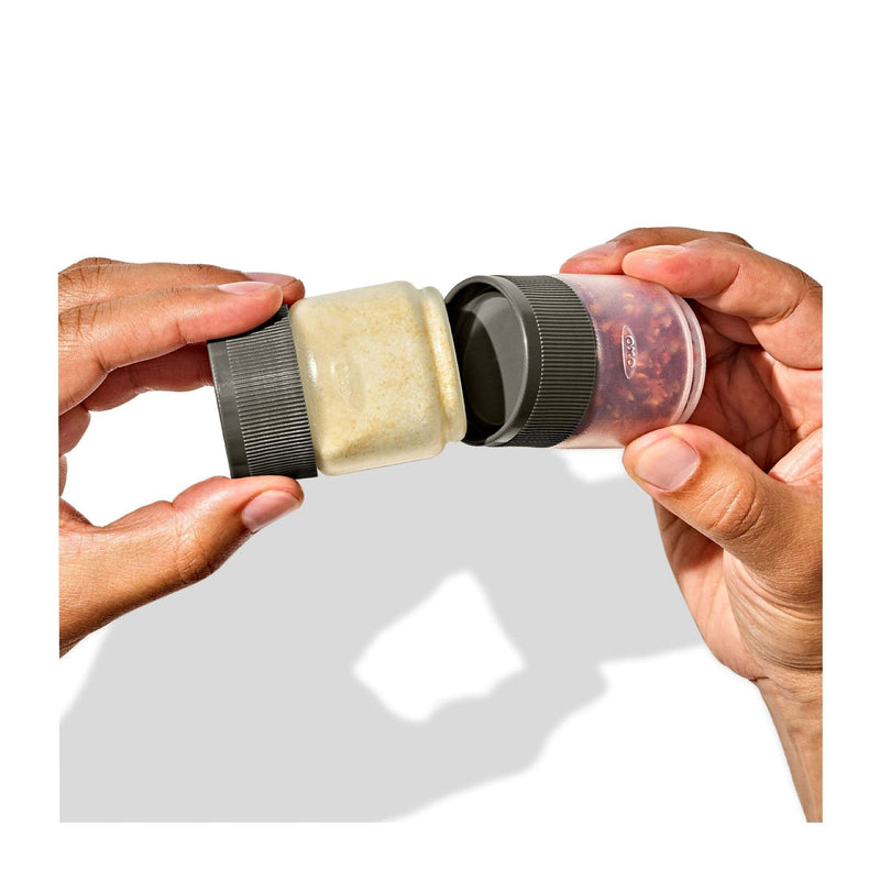 Load image into Gallery viewer, Two hands holding a spice grinder with a lid open, showing ground spices inside.
