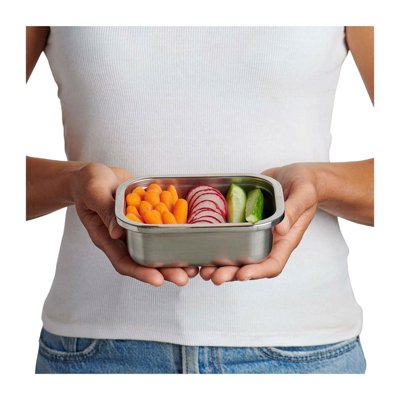 Load image into Gallery viewer, Person holding a metal lunch box with vegetables on a white background
