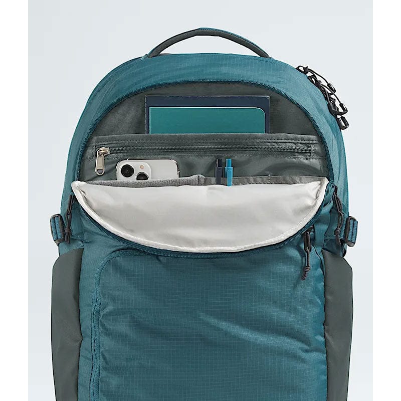 Load image into Gallery viewer, Teal backpack with compartments and items on a light blue background
