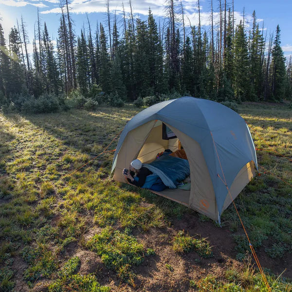 Load image into Gallery viewer, Person inside a tent in a forested area with trees and grass.
