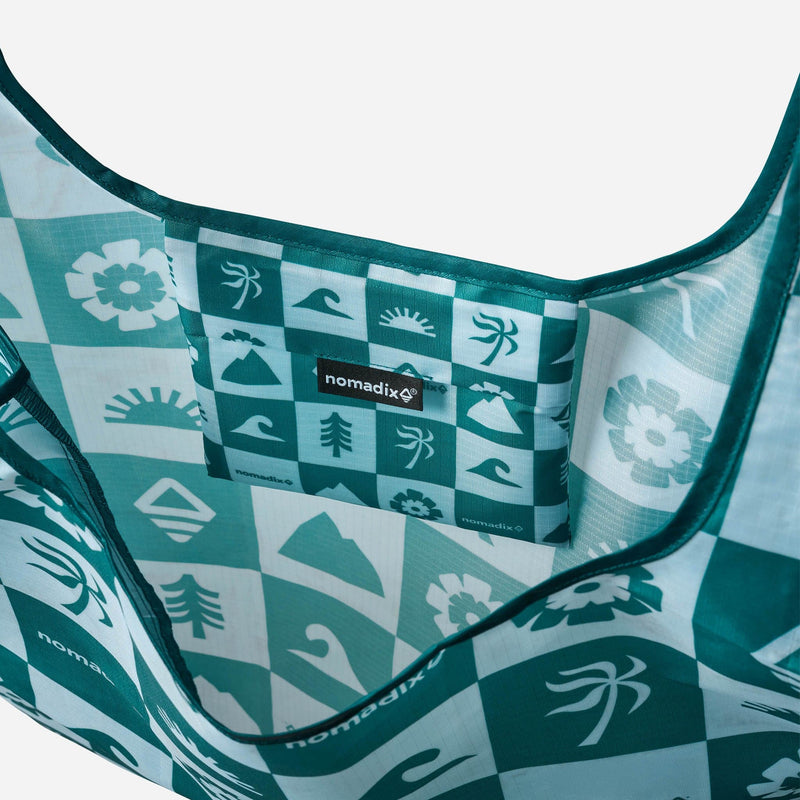 Load image into Gallery viewer, Close-up of a teal and white patterned hammock with 'nomadix' branding.
