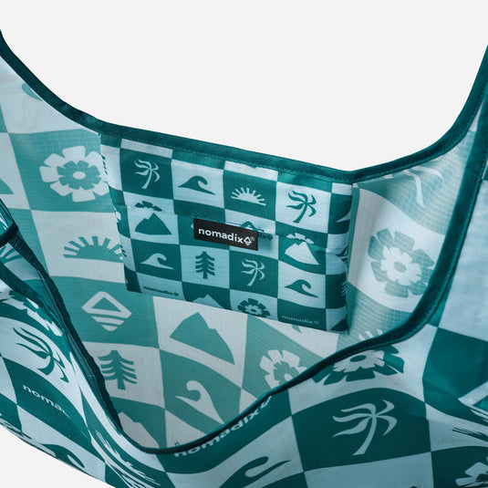 Close-up of a teal and white patterned hammock with 'nomadix' branding.