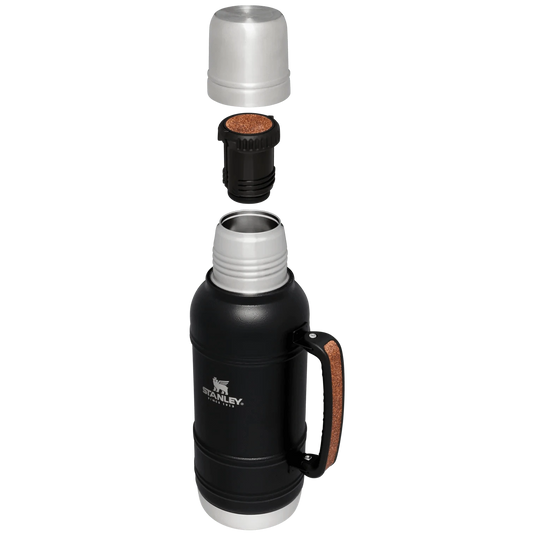 Black Stanley insulated mug with various lids on a white background