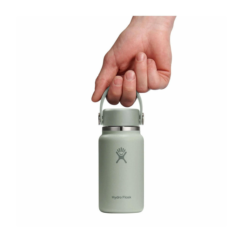 Load image into Gallery viewer, Hand holding a light green Hydro Flask bottle on a white background
