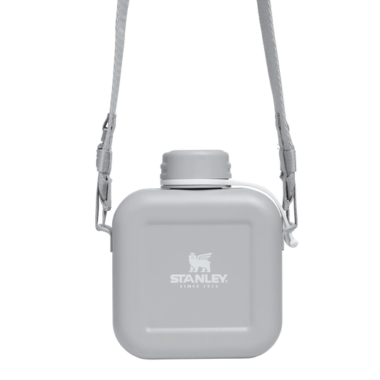 Gray water bottle with shoulder strap on a white background, featuring Stanley logo.