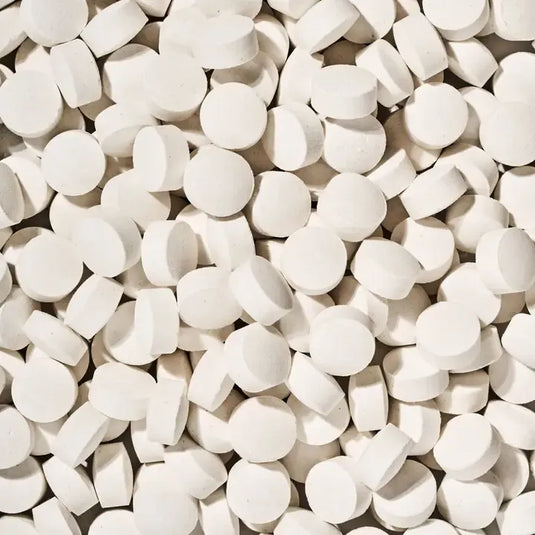 Close-up of a large pile of white tablets.