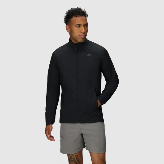 Man wearing a black jacket and gray shorts on a light gray background