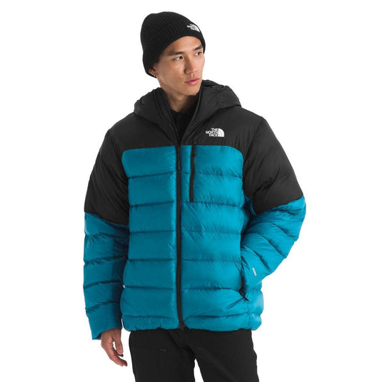 Person wearing a black and blue puffer jacket with a white background