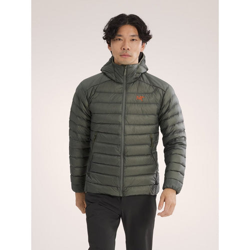 Person wearing a green puffer jacket on a light gray background