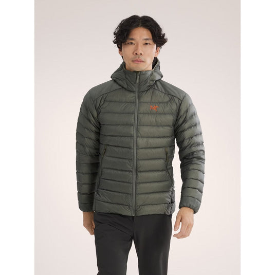 Person wearing a green puffer jacket on a light gray background