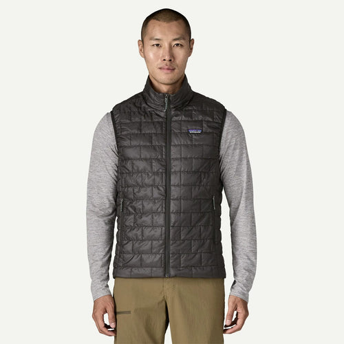 Man wearing a black quilted vest with a brand logo on a white background
