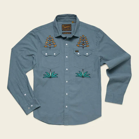 Blue shirt with embroidered designs on a beige background