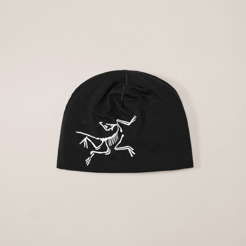 Black beanie with white skeleton design on a beige background