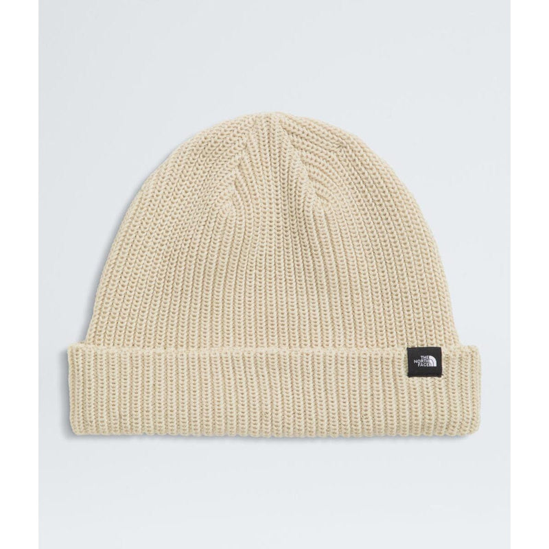 Load image into Gallery viewer, Beige knit beanie with a logo tag on a light gray background
