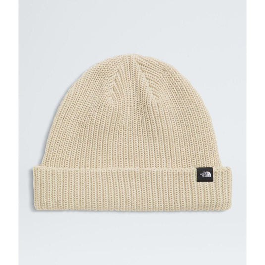Beige knit beanie with a logo tag on a light gray background