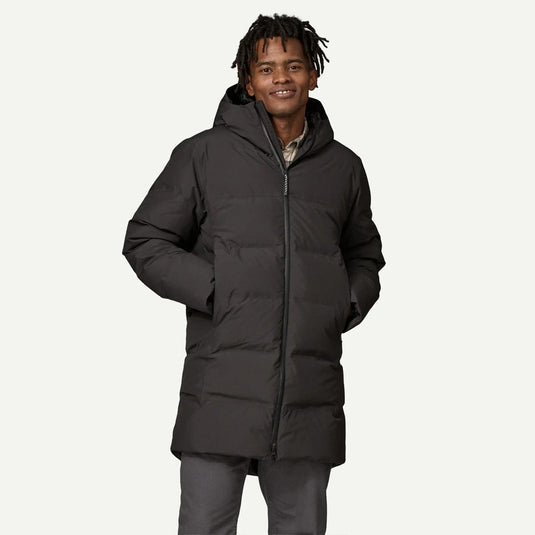 Man wearing a black puffer jacket on a white background