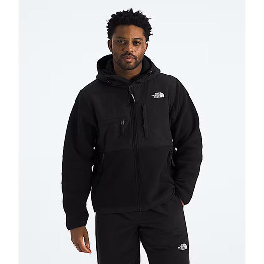 Person wearing a black jacket with a brand logo on a white background