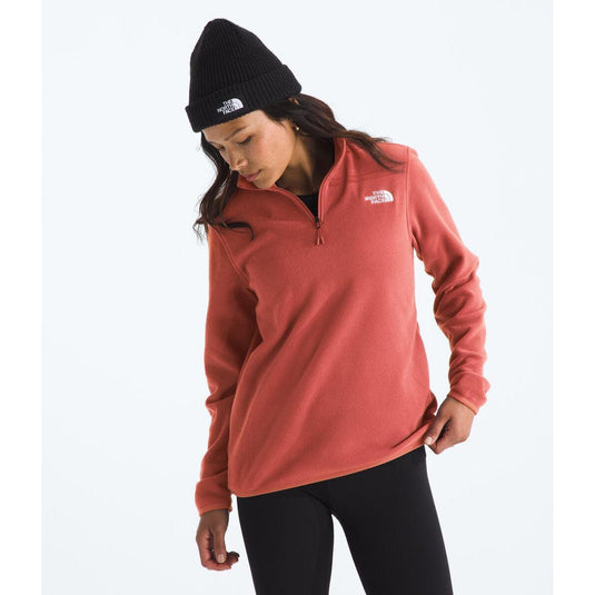 Person wearing a red fleece pullover and black beanie with The North Face logo on a white background