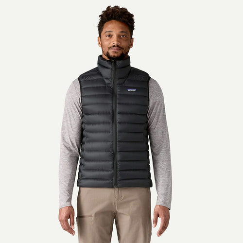 Man wearing a black puffer vest on a white background
