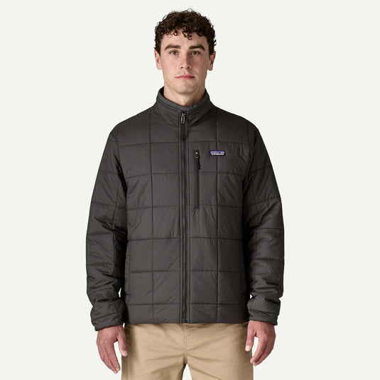 Man wearing a dark gray quilted jacket with a visible brand logo on a white background