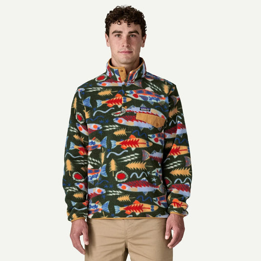 Man wearing a colorful patterned pullover with a visible brand logo on a white background