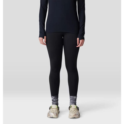 Person wearing black long-sleeve top and leggings with gray socks on a white background