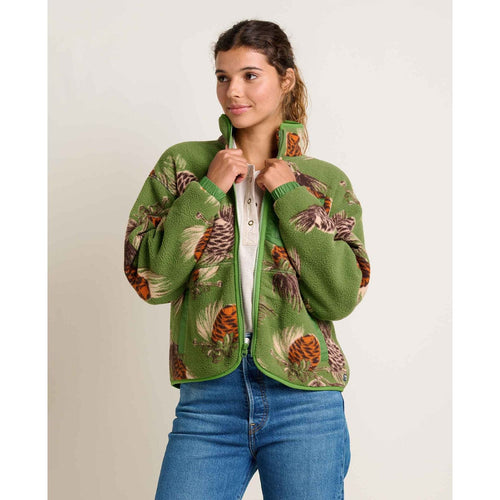 Woman wearing a green jacket with nature-themed pattern on a plain background