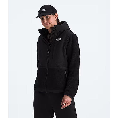 Person wearing a black hoodie and cap with The North Face logo on a white background
