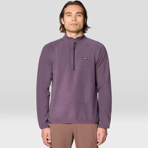 Man wearing a purple pullover with a small logo on a light gray background