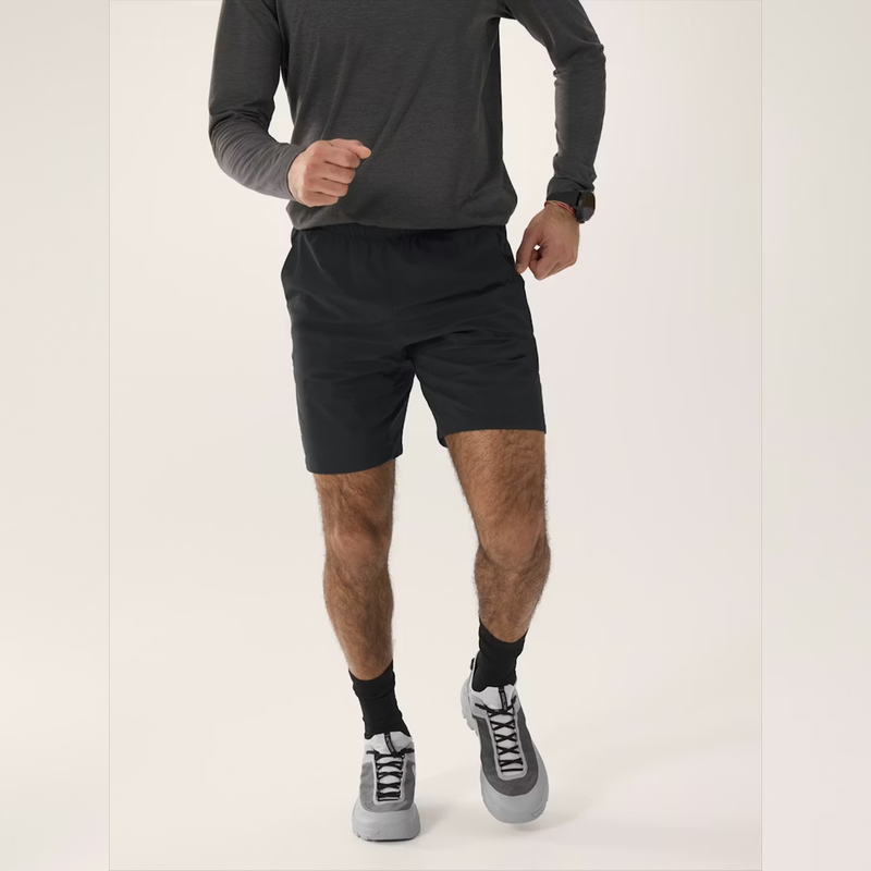 Load image into Gallery viewer, Person wearing black athletic shorts and gray sneakers on a white background
