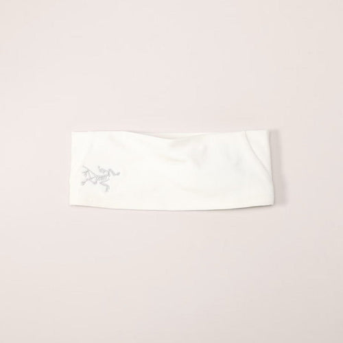White headband with a logo on a light pink background