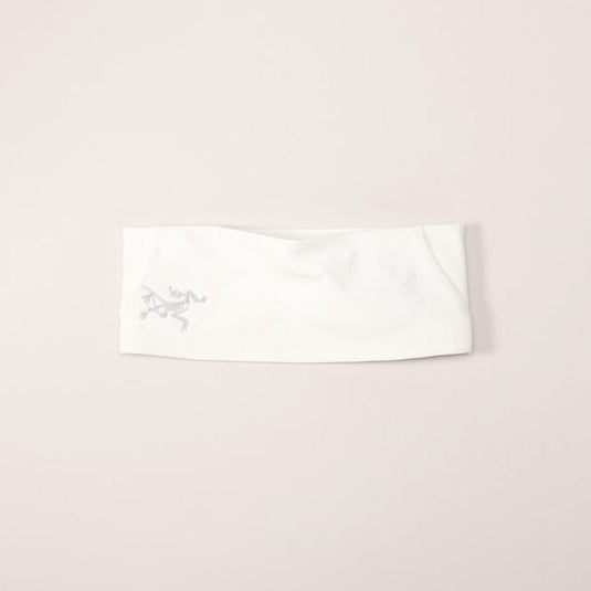 White headband with a logo on a light pink background